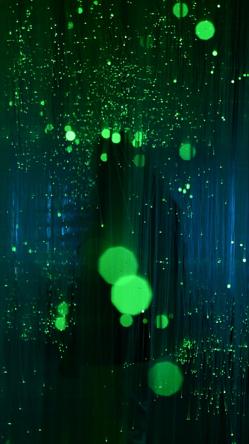 Green points of light suspended in darkness