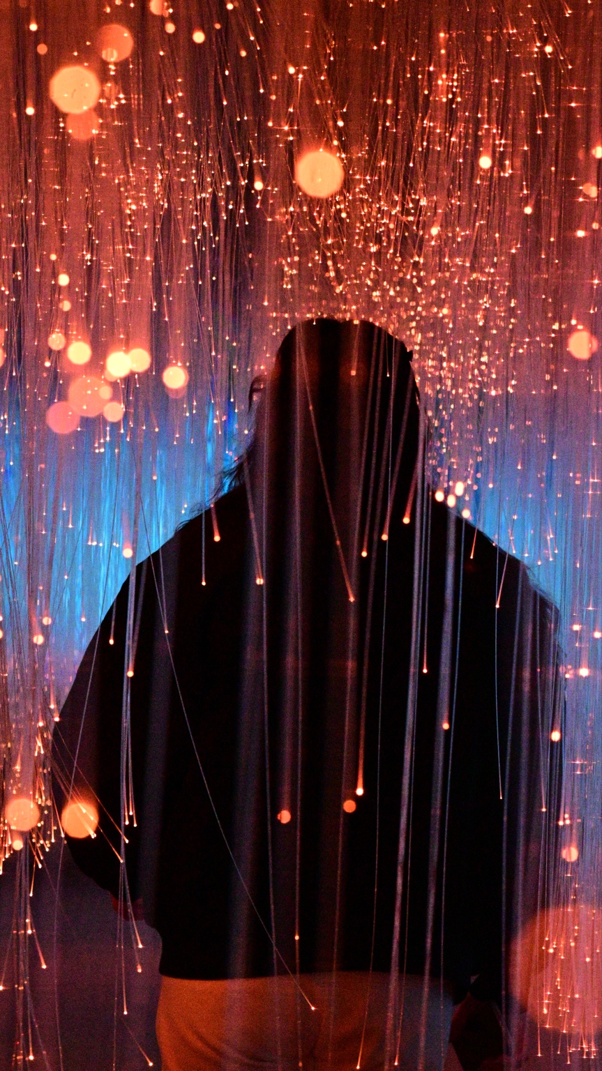 Silhouette beneath warm falling points of light